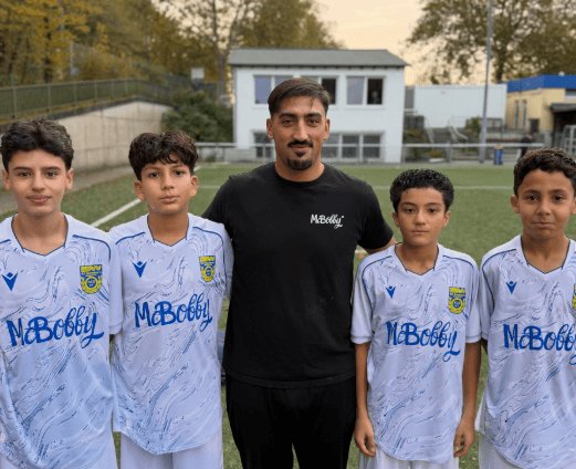 Vier Spieler der D1 in den neuen Trikots mit einem Vertreter von McBobby